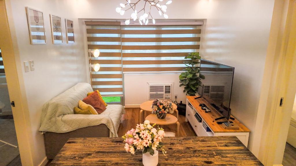 a living room with a couch and a table at Relaxing Mountain View 2BR Fast WiFi and PS5 in Manila