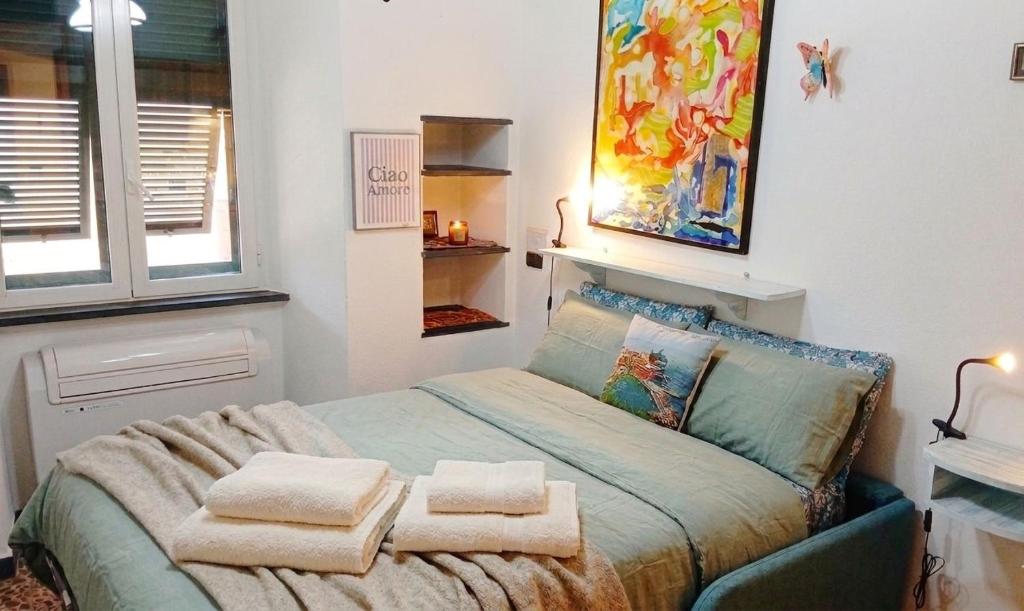 a bedroom with a bed with towels on it at Centralissimo e vicinissimo alla spiaggia , RILO Studio in Vernazza