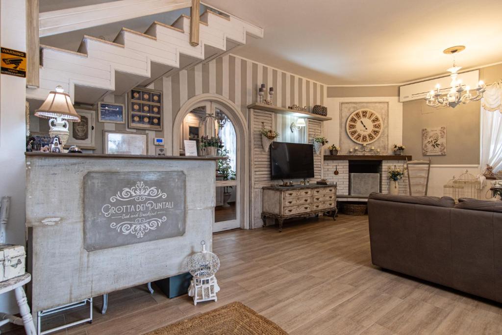 a living room with a couch and a tv at Grotta dei Puntali B&B in Carini