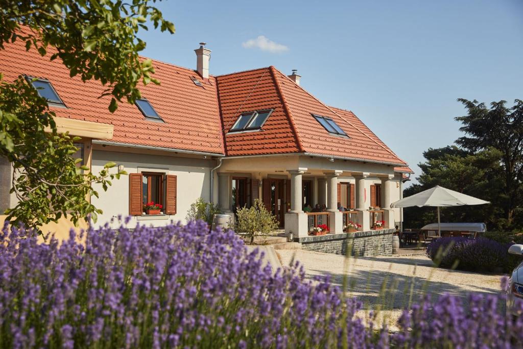 a house with purple flowers in front of it at Villa Tolnay Vendégház in Gyulakeszi