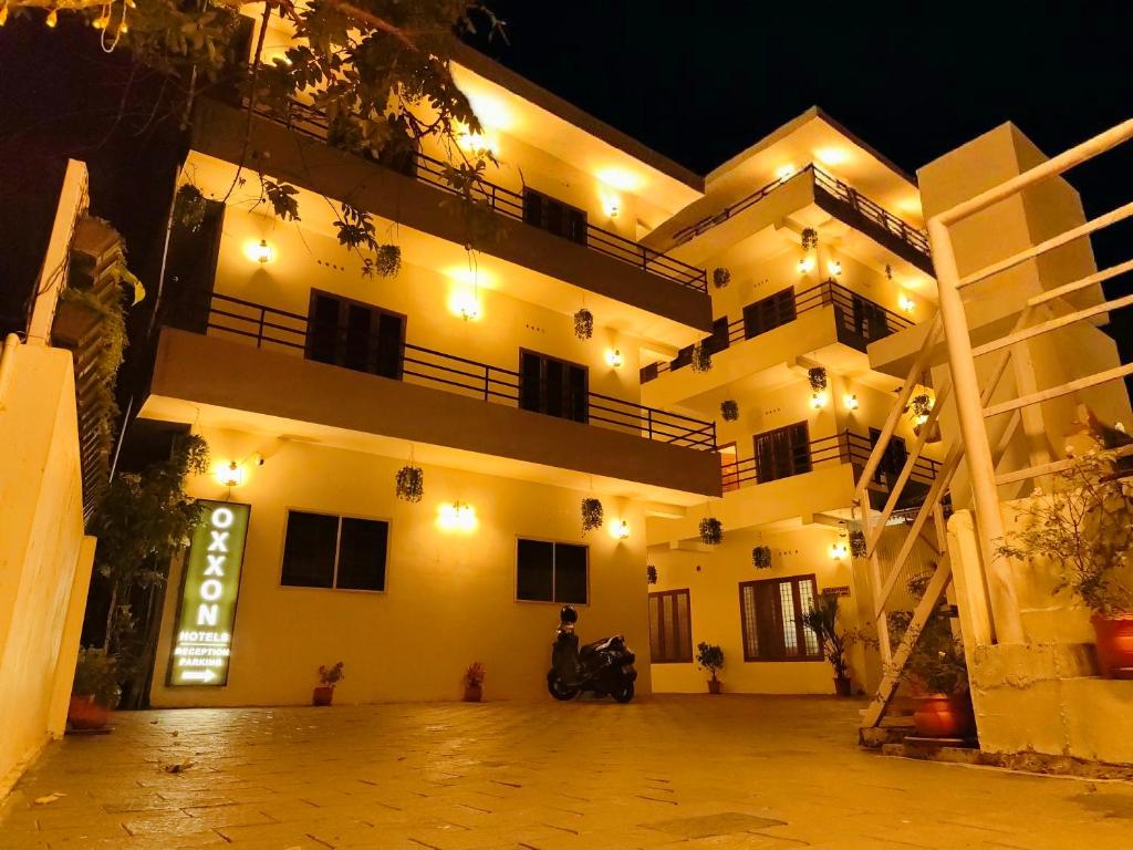 a large white building with a staircase in front of it at Oxxon Airport Hotel in Angamaly
