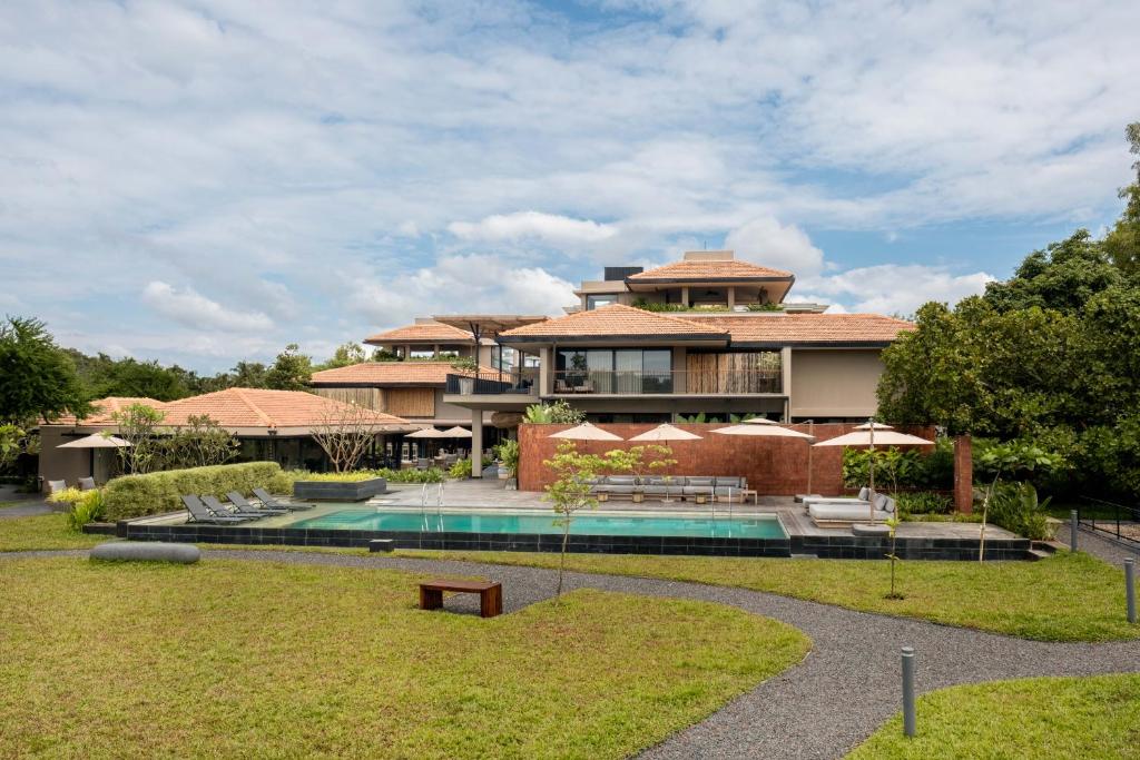 a large house with a swimming pool in front of it at Amaaranth Goa in Varca