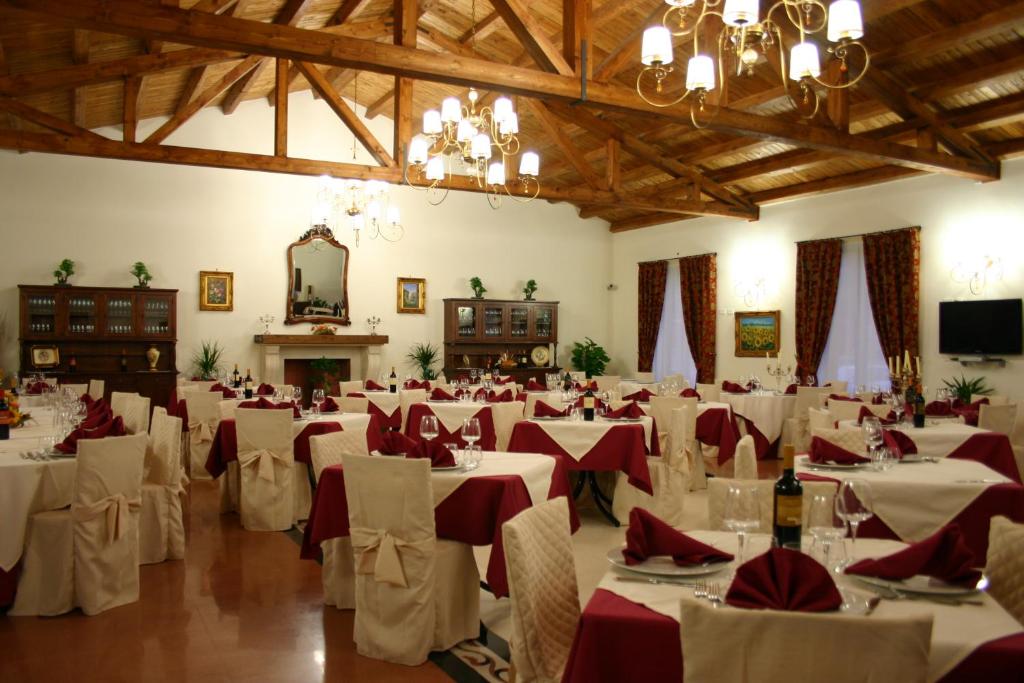 una grande sala banchetti con tavoli bianchi e tovaglioli rossi di Agriturismo Monticelli a Mussomeli