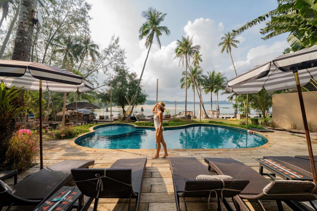 a woman in a bikini standing by a swimming pool at Tolani Resort Koh Kood in Ko Kood