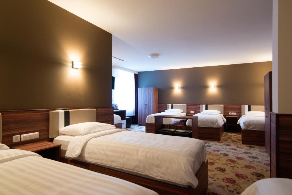 una camera d'albergo con 3 letti e una scrivania di Hotel King's Court ad Amsterdam