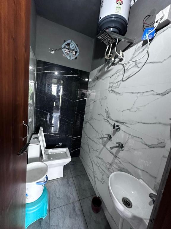 a bathroom with a white sink and a toilet and a sink at Taj hotel in Hisār