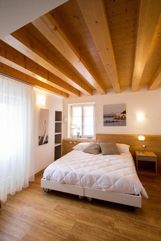 a bedroom with a large bed and a wooden ceiling at Hotel All'Arco in Trieste