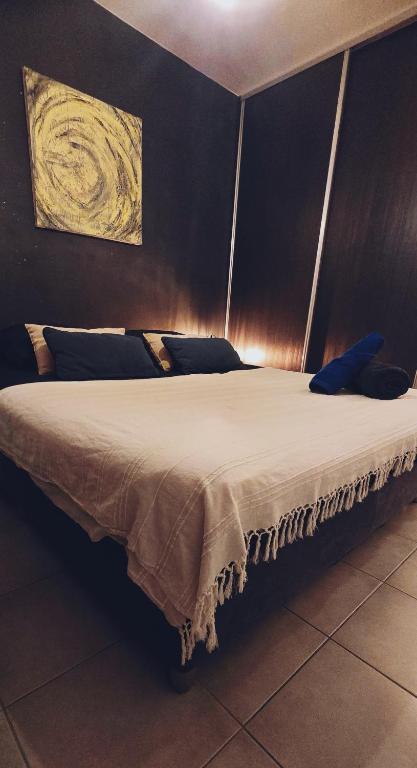 a bedroom with a large bed with white sheets at Cozy & Zen in Saint-Denis