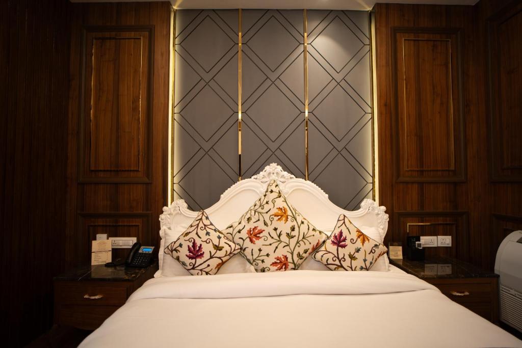 a white bed with pillows on top of it at Sindh Resorts in Srinagar