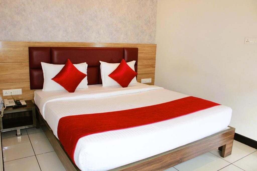 a bedroom with a large bed with red pillows at Mayuri Residency BTM Layout in Bangalore