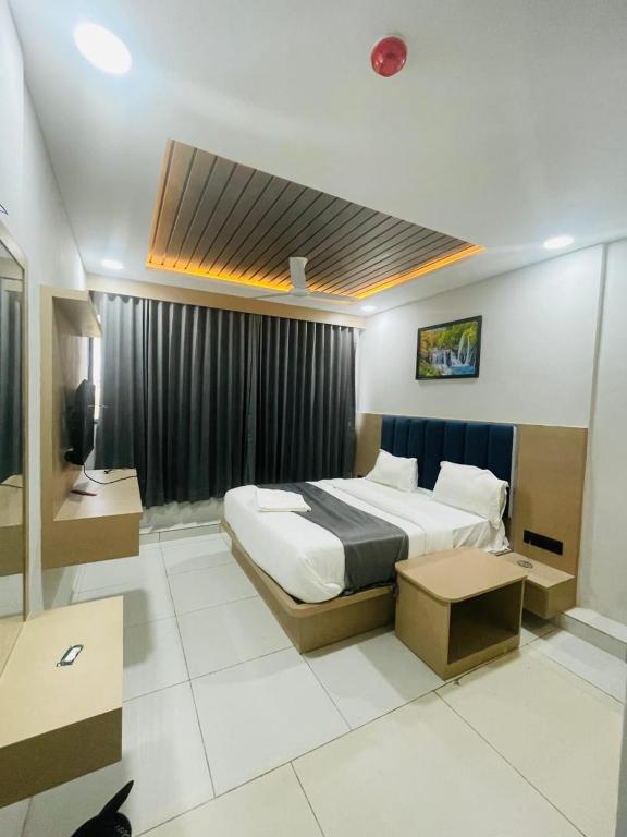 a hotel room with a bed and a window at Hotel hills in Ahmedabad
