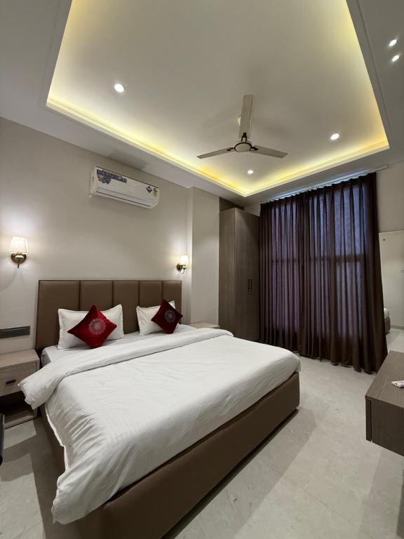 a bedroom with a large white bed with red pillows at Hotel sky inn in Jalandhar