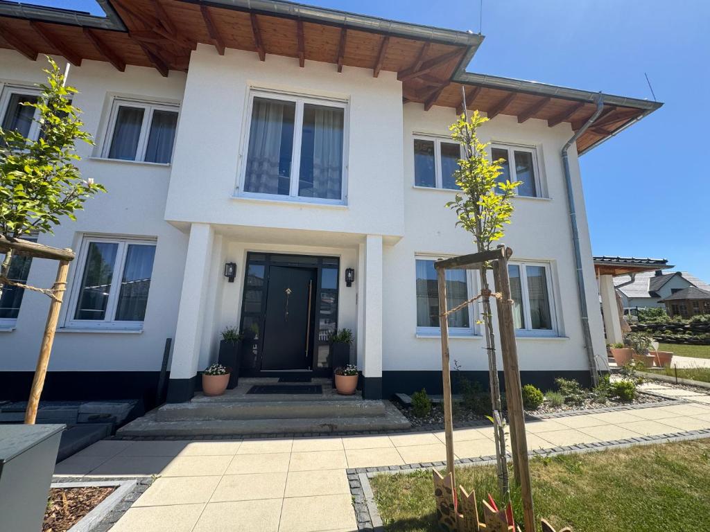 a white house with a black door at Pension "Zum Romröder Steingarten" in Romrod