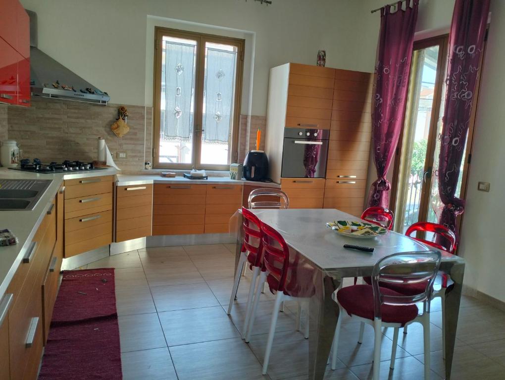 a kitchen with a table and some red chairs at terrazza sul castello in Roccella Ionica