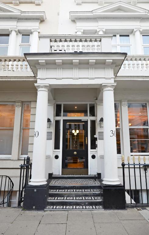 a white building with a door and columns at The Portico Hotel in London
