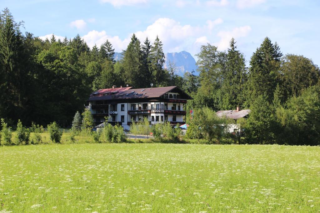 a large house in the middle of a field at Hotel Köppeleck in Schönau am Königssee