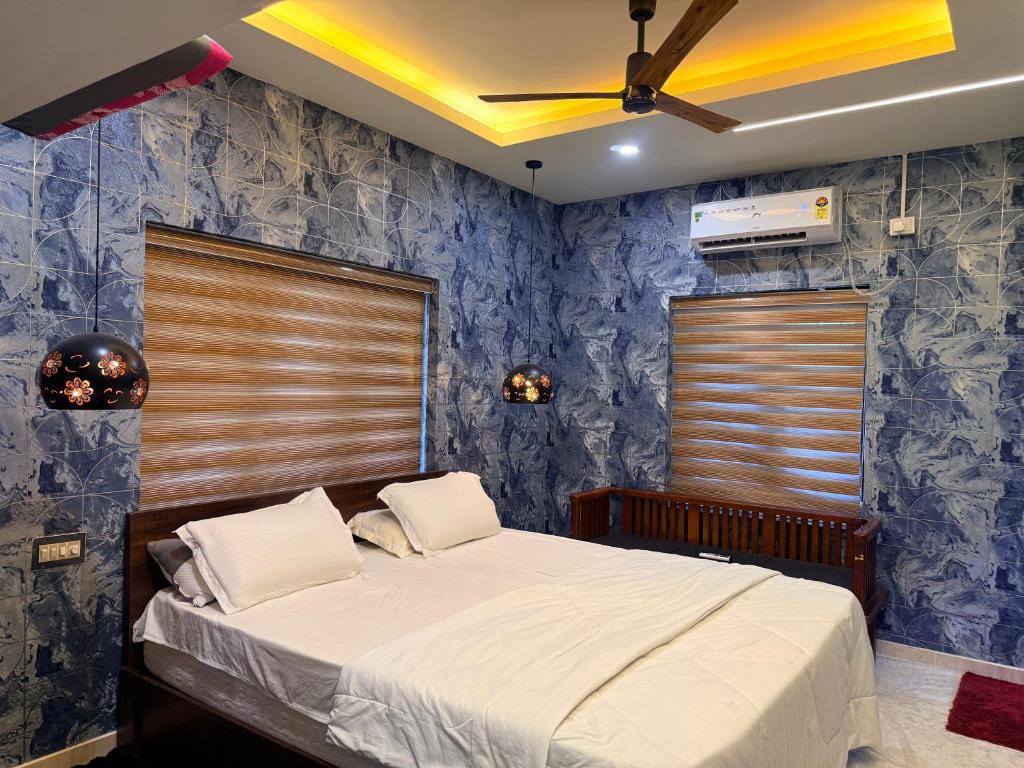a bedroom with a bed with a blue wall at Winter Heaven in Cochin