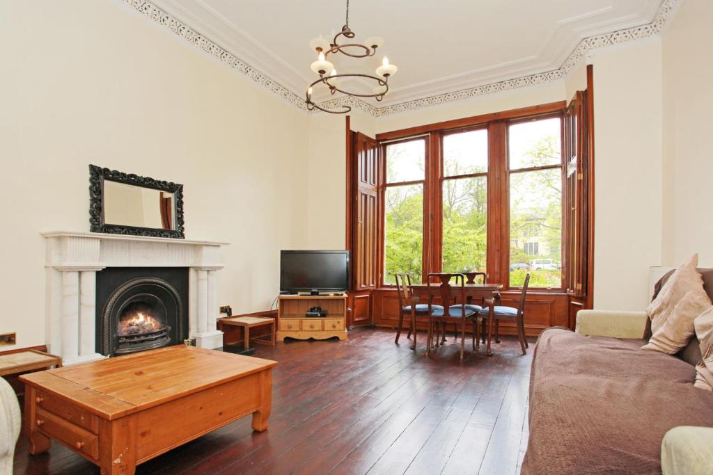 a living room with a couch and a fireplace at Broompark House in Glasgow