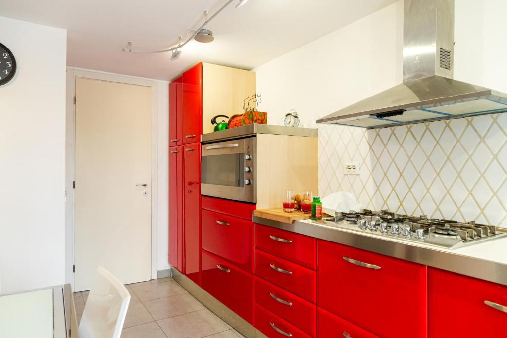a red kitchen with red cabinets and a microwave at Villa Penelope in Terracina