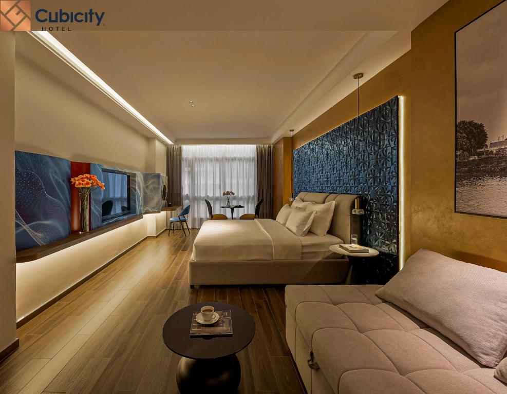 a hotel room with a bed and a couch at Cubicity Hoang Dieu in Ho Chi Minh City