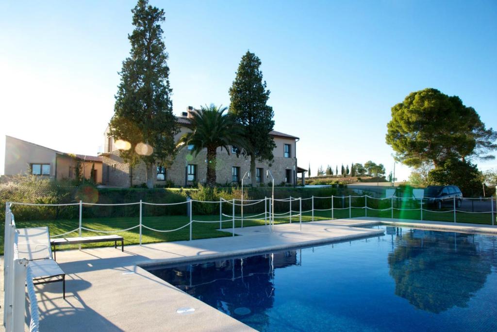 a swimming pool with a fence and a house at Hotel Villa Monter in Alcañiz