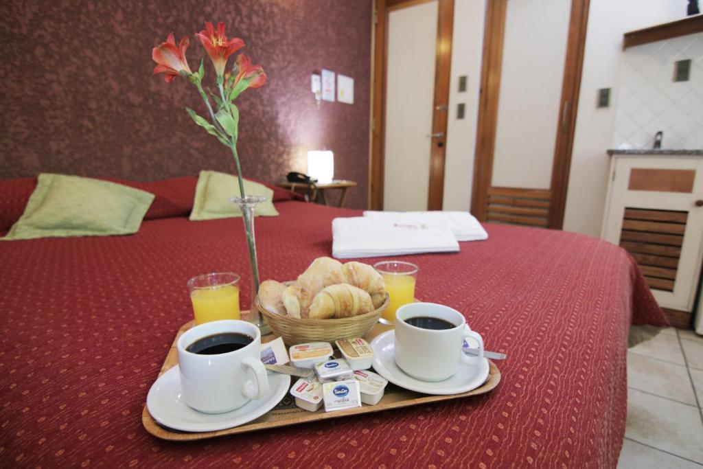 Una bandeja con dos tazas de café y una cesta de pan. en Hotel Xumec Mendoza en Mendoza