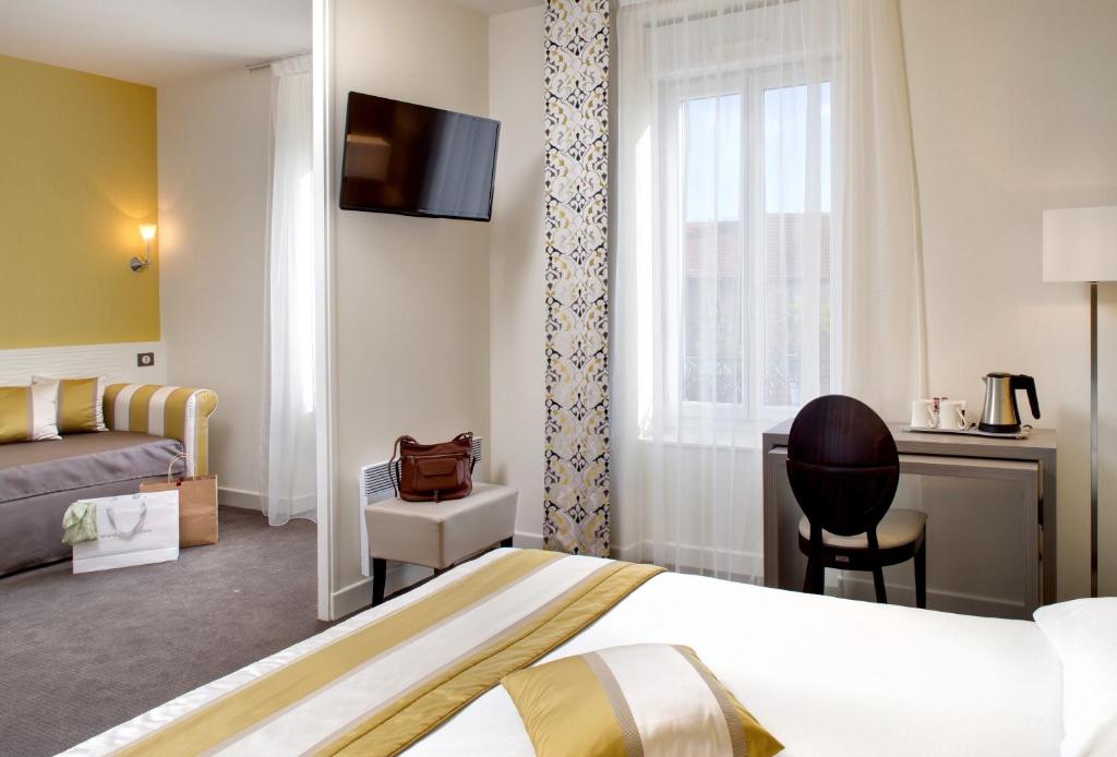 a hotel room with a bed and a desk at HOTEL ARVERNA VICHY - ClT'HOTEL in Vichy