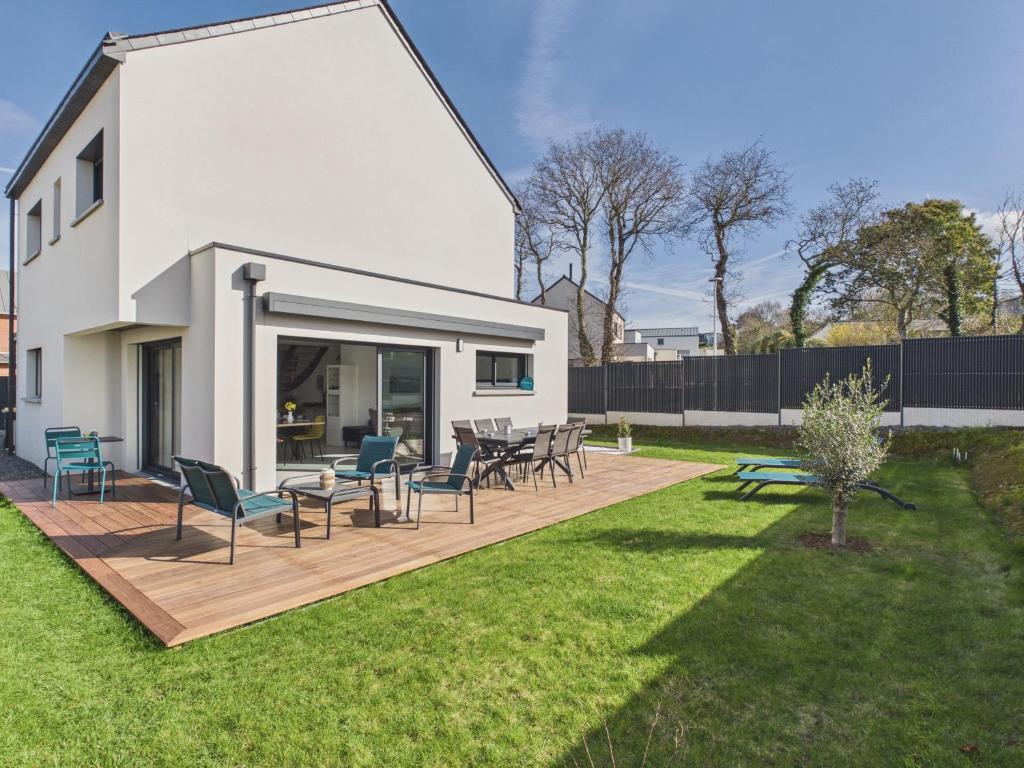 a patio with chairs and tables in a yard at Superbe maison récente pour 8 avec jardin in Pléneuf-Val-André