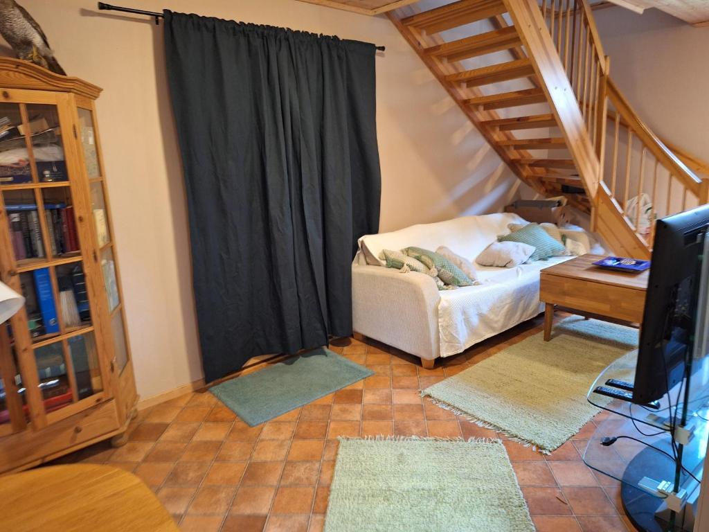 a living room with a bed and a television at Slettavegen1a in Time