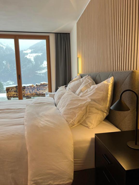 a bedroom with a large bed with white sheets and pillows at Alpencabin Montafon in Vandans