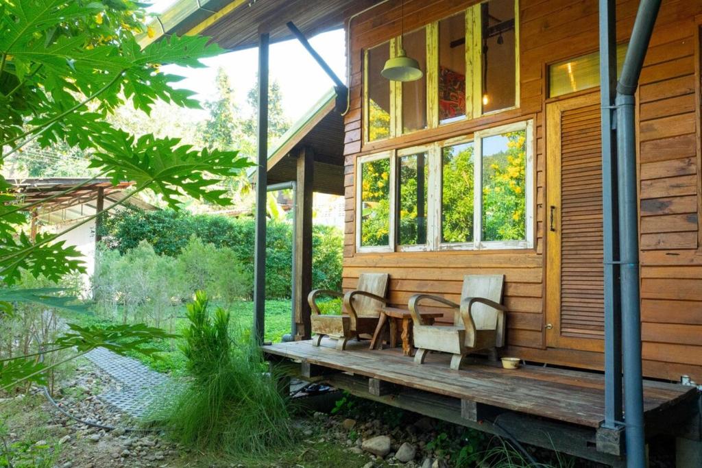 a house with a table and chairs on a porch at MaPin in Ban Thung Kong Mu