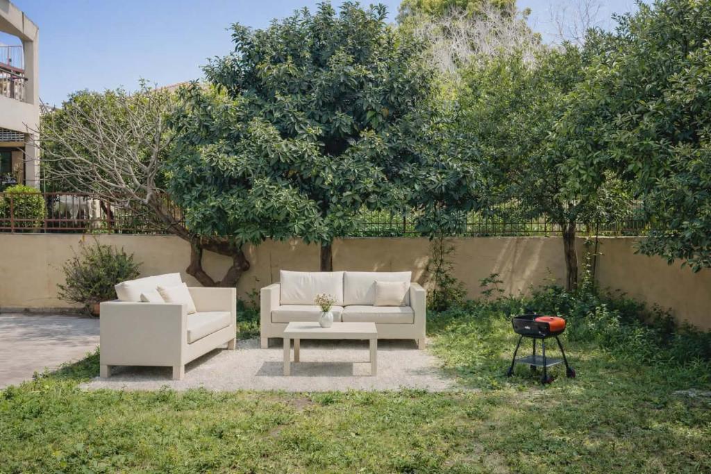 two white couches and a table in a yard at Yviome Rhodes Central Escape in Rhodes Town