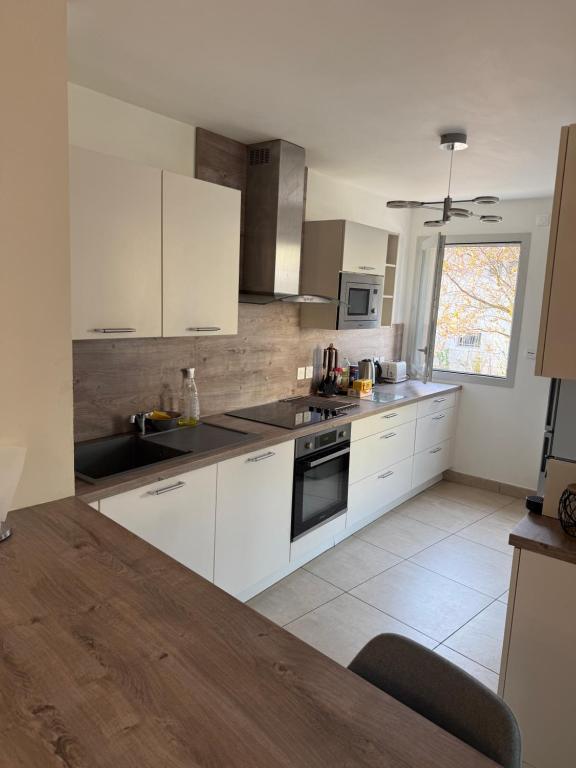 a kitchen with white cabinets and a counter top at Résidence inside in Ferney-Voltaire