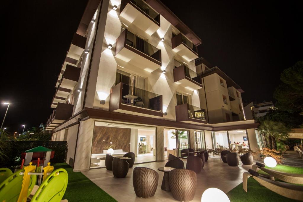 un bâtiment avec beaucoup de chaises devant lui dans l'établissement Hotel Pineta Mare, à Lido di Camaiore