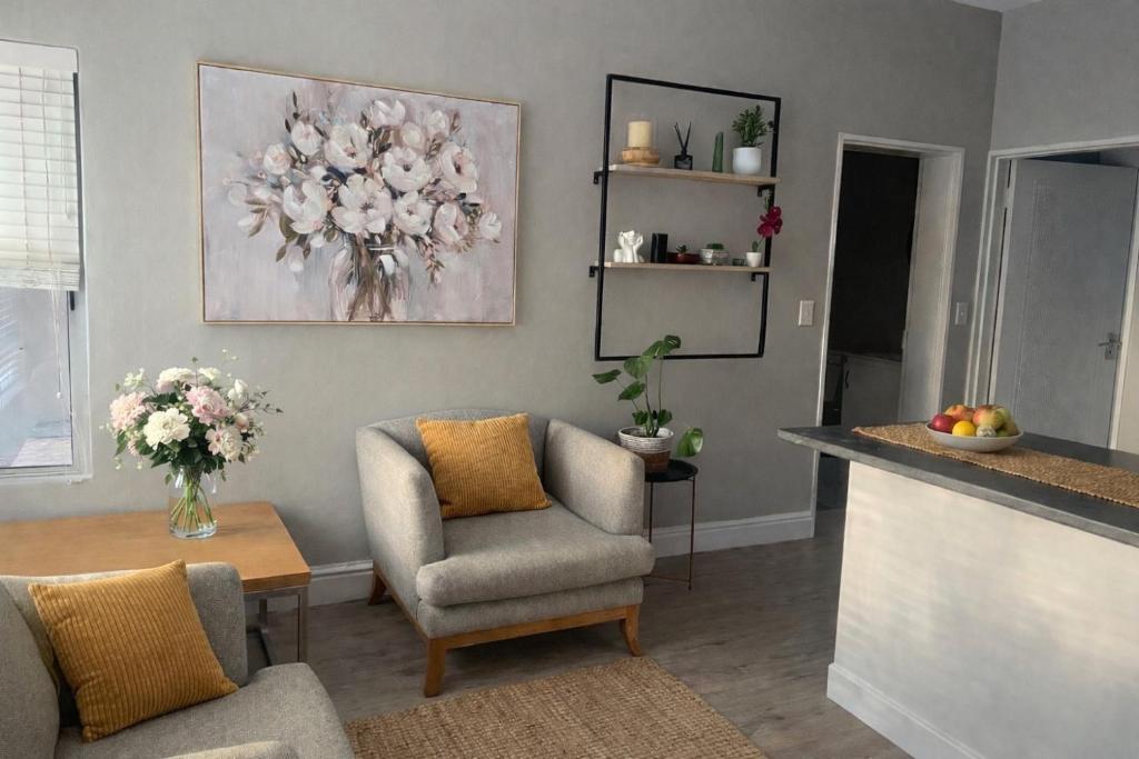 a living room with a chair and a table at Tijger Haven in Tygerberg Hills