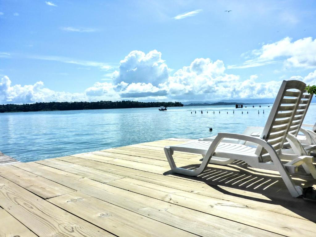 a pair of chairs sitting on a dock next to the water at El Jaguar in Bocas Town