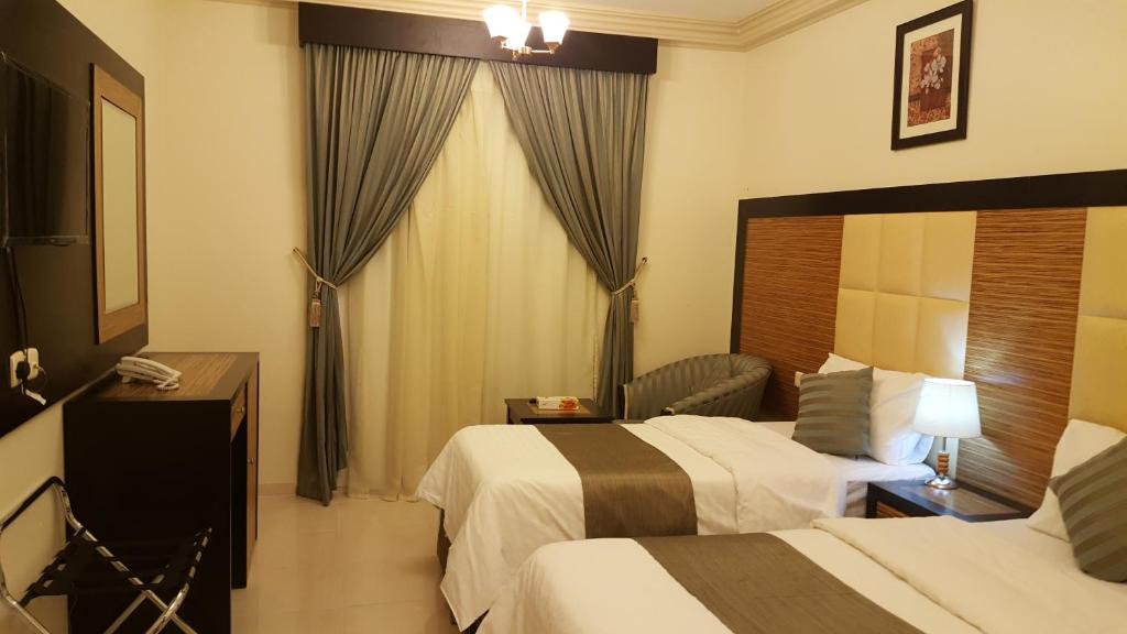 Postel nebo postele na pokoji v ubytování ديار المشاعر الهداية الفندقية Diyaralmashaer Al-Hadiyah Hotel