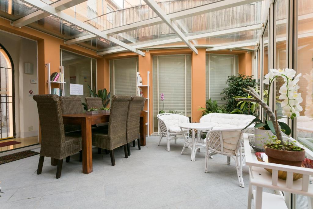oranżerią ze stołem i krzesłami na patio w obiekcie Relais Pacinotti Apartments w Pizie