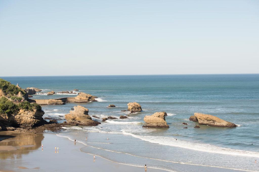 a view of a beach with rocks and the ocean at Hôtel Le Windsor Biarritz in Biarritz