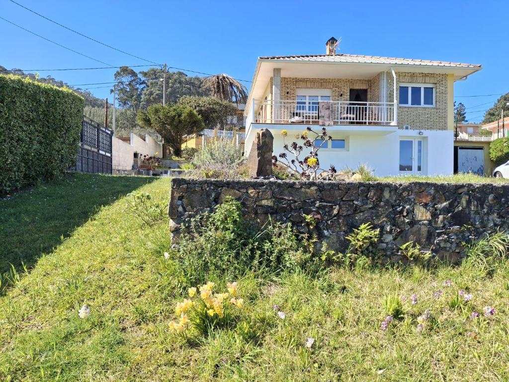 a house on a hill with a stone wall at Mar de Pantin in Valdoviño