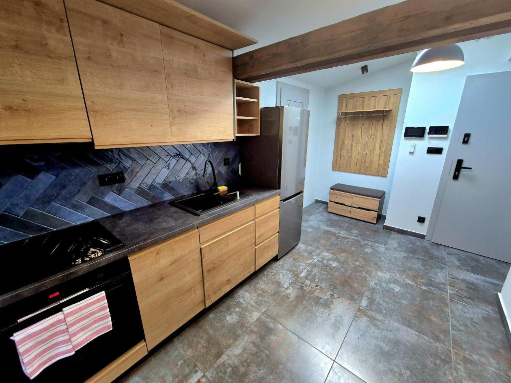 a kitchen with wooden cabinets and a stove top oven at Apartament Mickiewicza 6 in Września
