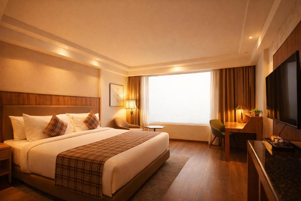 a hotel room with a bed and a large window at Pride Premier Darjeeling in Darjeeling