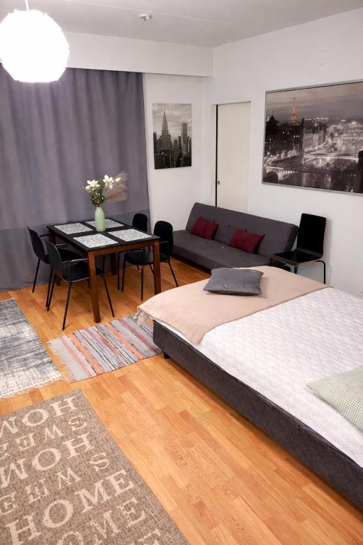 a bedroom with two beds and a table and a couch at Top in Oulu