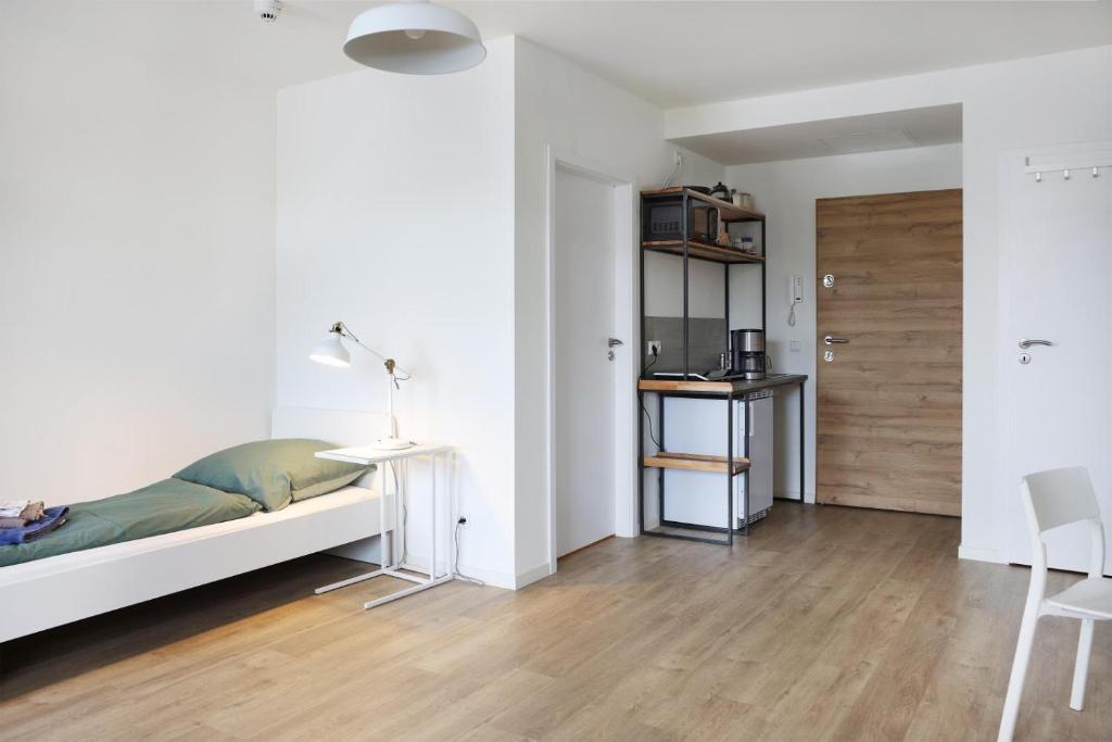 a white bedroom with a bed and a table and chairs at Zentrale Monteurwohnung in Oldenburg i H in Oldenburg in Holstein