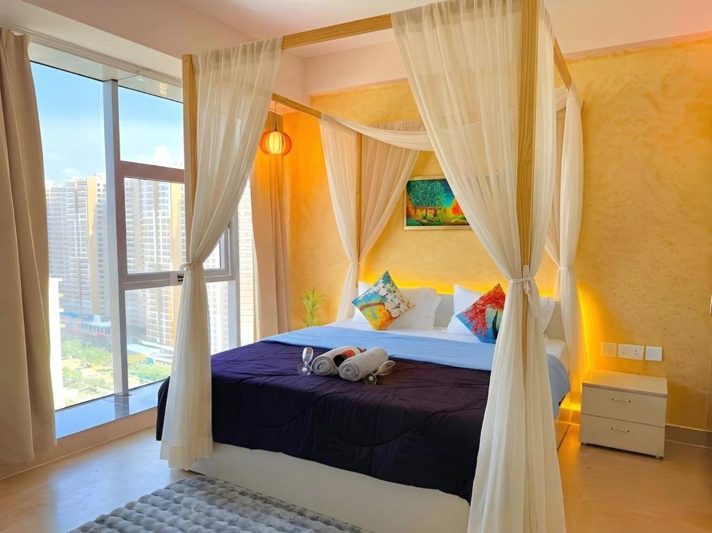a bedroom with a canopy bed with a window at 1BHK Suite with Balcony and Pool View in Noida