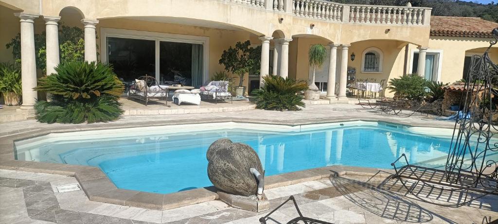 a swimming pool in front of a house at Les murmures du jardin in Pégomas