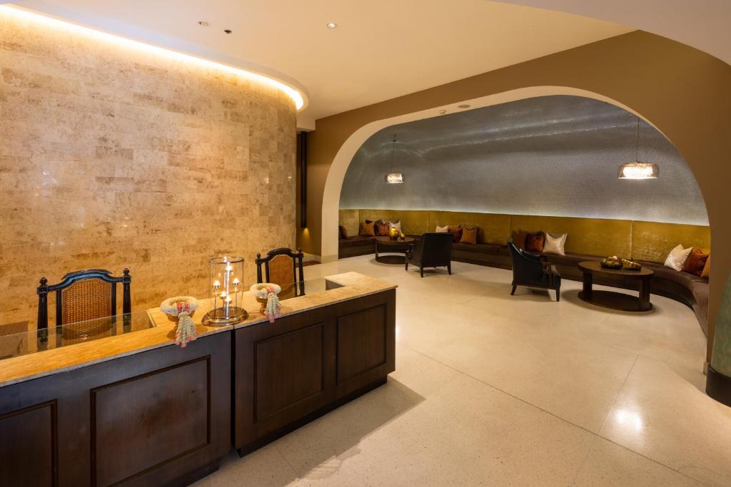 A lobby reception desk facing an arched lounge with built-in seating.