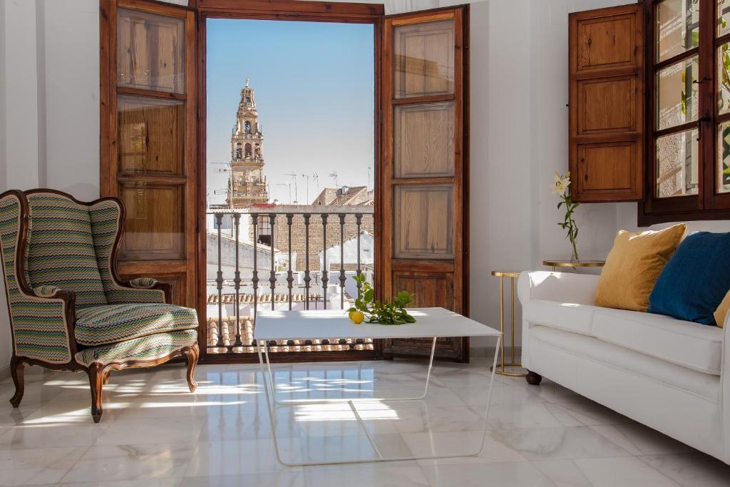 sala de estar con sofá, mesa y ventana en El Jardín de Wallada, en Córdoba