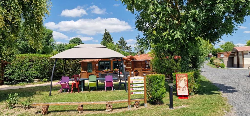 a gazebo with colorful chairs and a table and a building at Le Pont Rouge & Les Vignes in Chipilly
