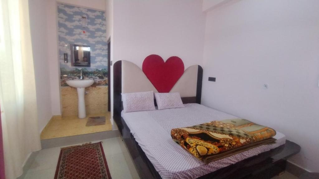 a bedroom with a bed with a heart on the wall at VAIBHAV VILAs in Gangolihāt